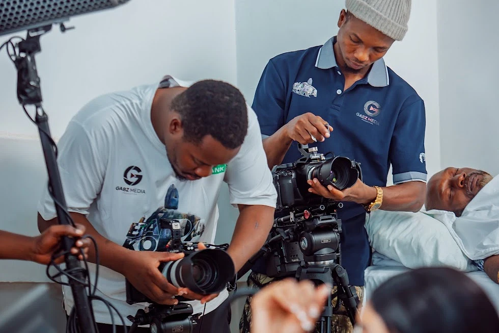 Two camera operators filming a hospital bed scene