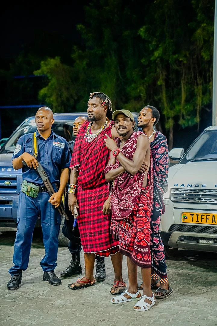 Cast in red shukas beside a police officer in a night scene